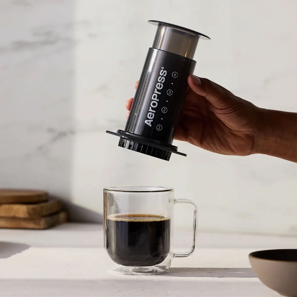 Person pressing an AeroPress Premium to brew a cup of coffee