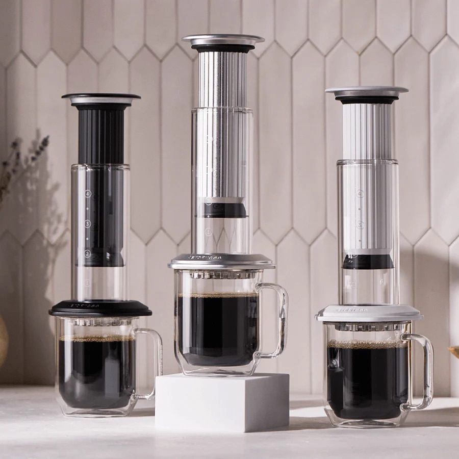 Three AeroPress Premium brewers in different finishes lined up side by side